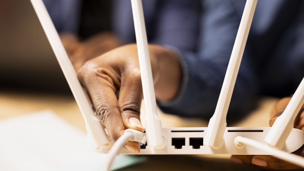 young black woman pulling out lan cable from modem