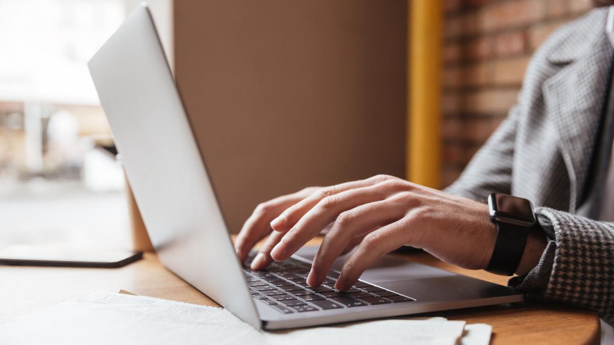 cropped image businessman eyeglasses sitting by table cafe using laptop computer
