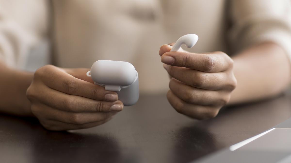 hands holding wireless earphones case